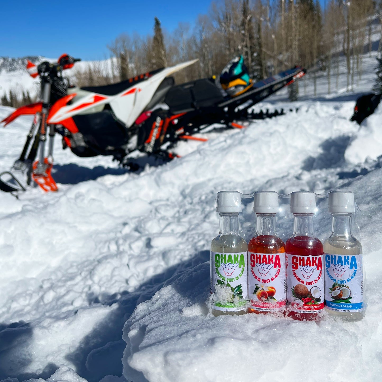 Dirty soda mixers on snow next to a snow bike in Utah