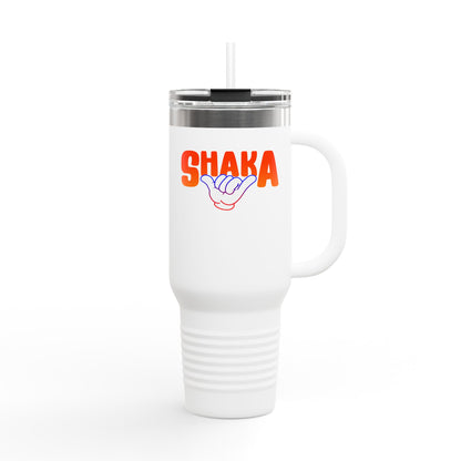 The Printify Insulated Travel Mug, 40oz, is a tall white stainless steel tumbler with a handle and straw, featuring “SHAKA” in bold orange above a purple shaka hand sign, shown against a plain white background.